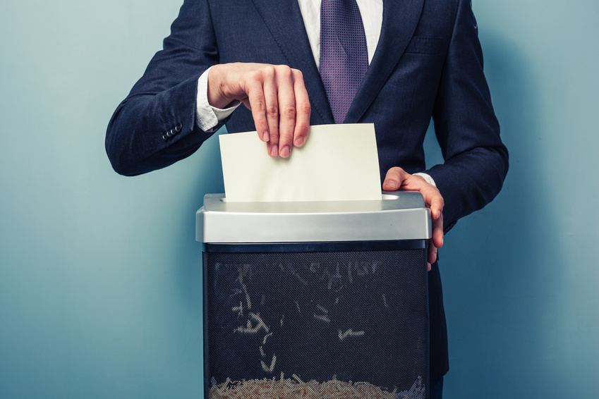 A Businessman is shredding important documents